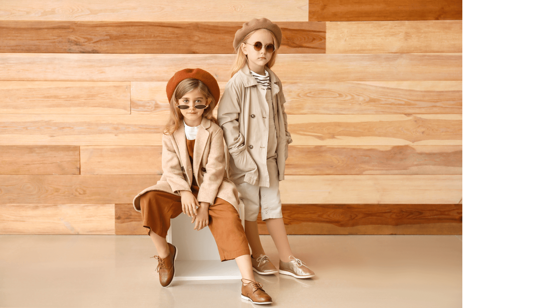 Two girls wearing coordinated neutral outfits and berets