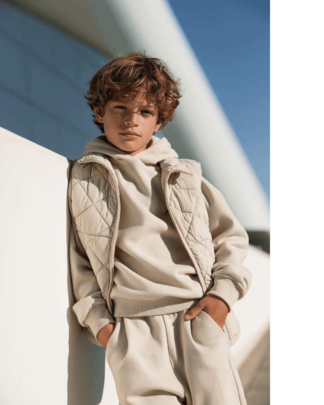 Boy wearing a neutral jacket and casual outfit