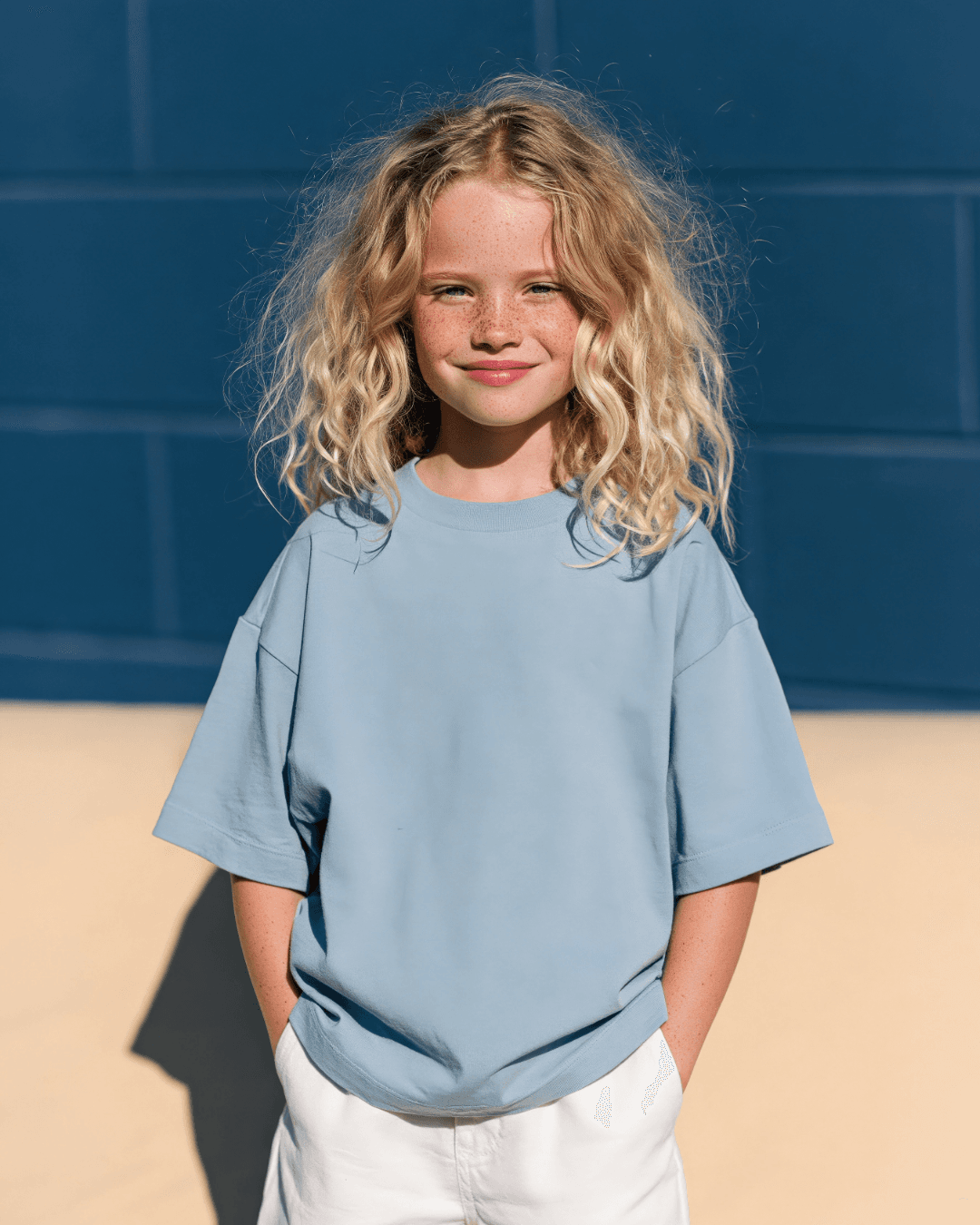 Girl in a blue shirt standing in sunlight