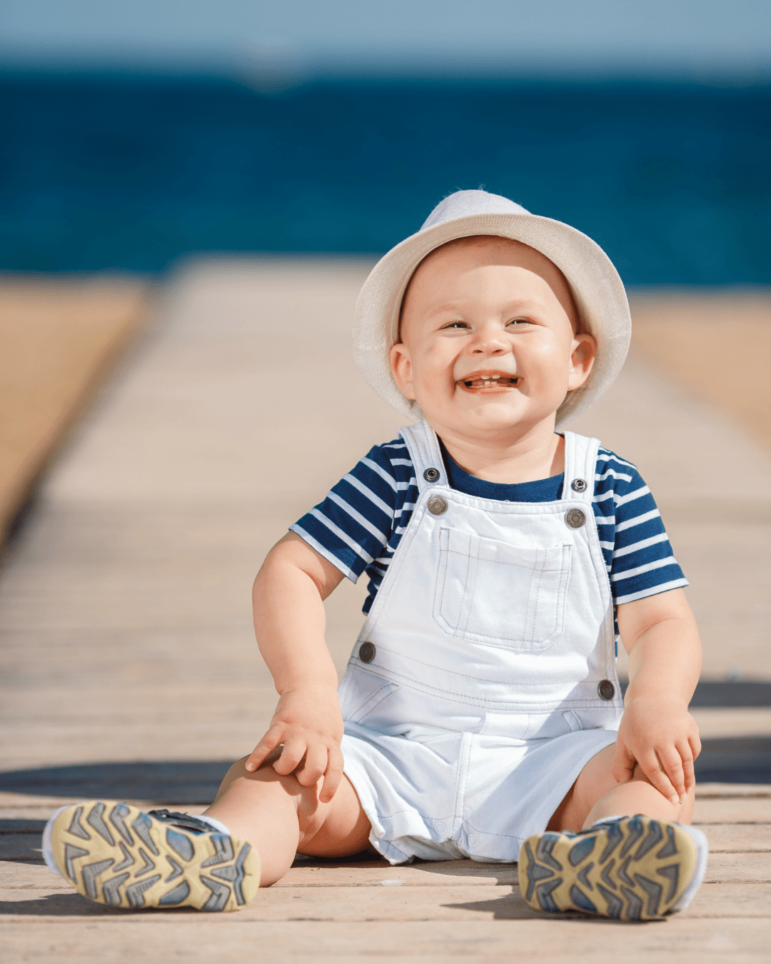 Smiling baby in a blue striped outfit